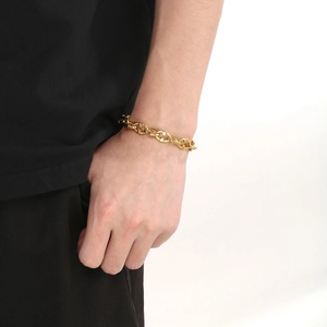 Bracelet tendance en acier titane doré à maillons mufle de porc porté par un mannequin chic