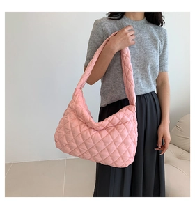 Close-up of a pink quilted puffer tote bag featuring a diamond stitched pattern and wide strap