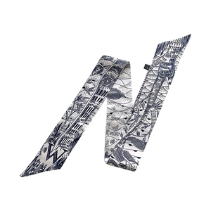 Detailed view of silk twilly scarf with navy blue architectural patterns and floral print