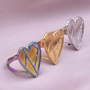 Three geometric heart-shaped stainless steel rings in iridescent gold and silver colors