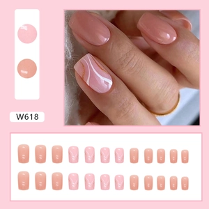 Press-on nails in nude pink with white wave swirls and gold glitter decoration