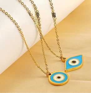 Detailed macro view of golden stainless steel evil eye pendant with blue enamel inlay