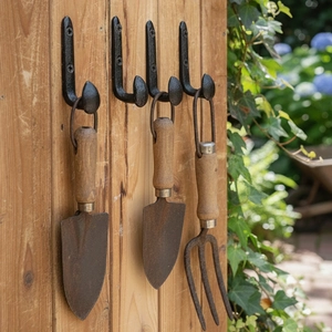 Set of four vintage cast iron wall hooks with round tips for garden tools or clothing