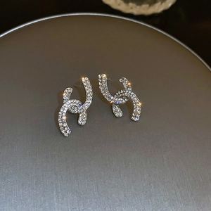 Macro shot of silver interlocking CC stud earrings with sparkling pave-set zircons