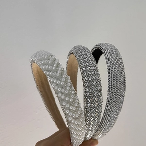 Detailed close-up of three wide headbands with white pearls and sparkling silver rhinestones