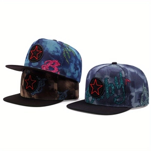 Detailed close-up of camouflage snapback caps with star badges and glitter embroidery