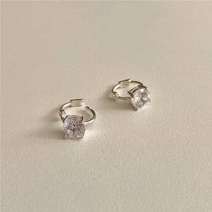 Close-up of 925 silver stud earrings with four-prong set round clear cubic zirconia stones