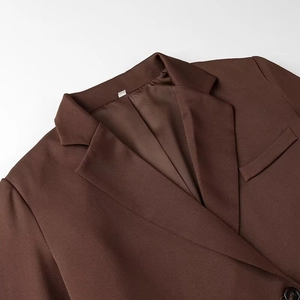 Détail du revers asymétrique d'un blazer marron foncé avec doublure de haute qualité
