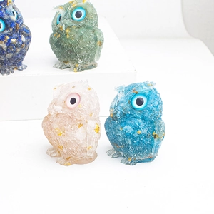 Detailed view of four colorful resin owl figurines with gold foil and crystal stones