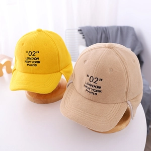 Close-up of winter fleece ear protection caps with 02 LONDON embroidery on wooden stands