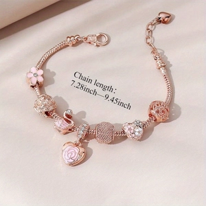 Bracelet à perles or rose avec breloques rose, cygne et cœur sur fond doux satiné