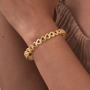 Elegant gold heart-shaped hollow stainless steel bracelet worn on a female wrist
