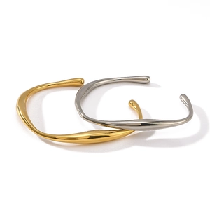 Irregular liquid metal style bangles in 18K gold and silver finish on white background