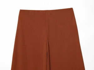 Detail of caramel high-waist wide-leg trousers showing smooth fabric and tailored waistline