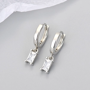 Minimalist silver hoop earrings with rectangular clear zircon drops on light background