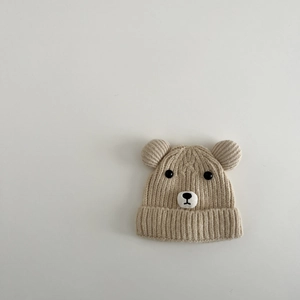 Détail d'un bonnet d'hiver en tricot beige avec oreilles d'ours et texture côtelée épaisse