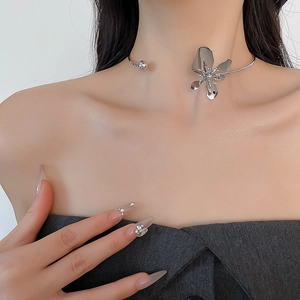 Detail of silver metallic flower choker necklace with polished bead on fashion model