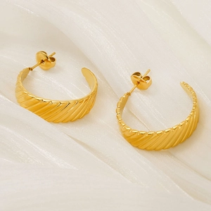 Minimalist 18K gold C-shape earrings with diagonal textured surface on white silk