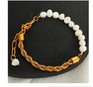 Detail of twisted gold chain and irregular white pearl splice bracelet with extender