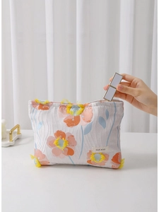 Floral embroidered makeup bag with large capacity being filled with lipstick on a desk