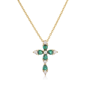 Macro view of gold cross necklace featuring pear-cut green and white cubic zirconia