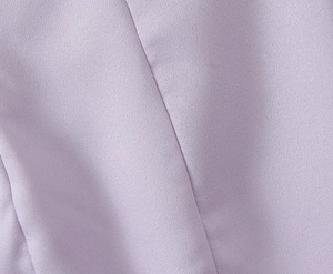 Gros plan sur la texture du tissu lilas et les détails de couture de la robe moulante