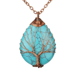Close-up of tree of life copper wire wrapping on turquoise teardrop pendant