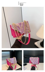 Detail of rose red crossbody bag with marble pattern purple velvet flap and gold chain