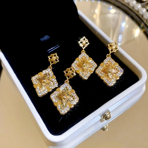 Gros plan de boucles d'oreilles vintage avec zircon blanc et placage d'or en boîte