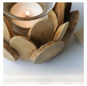 Close-up of rustic driftwood candle holder with glass cup and burning white candle