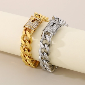 Detail view of gold and silver Cuban link bracelets with CNC diamond clasp on a display stand