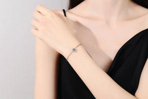 Close-up of snowflake bracelet with round moissanite on a model's wrist