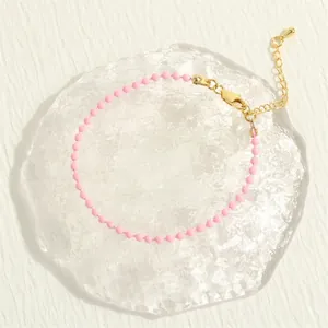 Detail shot of macaron pink beads and golden lobster clasp on Bohemian stretch bracelet