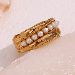 Close-up of a tiered 18K gold-plated ring with layered pearls and a textured water-drop surface