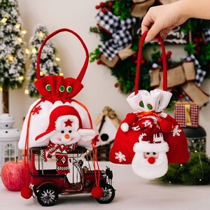 Détail de sacs cadeaux de Noël tricotés avec personnages 3D du Père Noël et bonhomme de neige