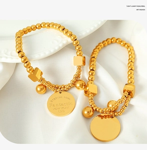 Detail of 18k gold plated stainless steel beaded bracelets with geometric charms on silk