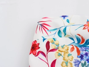 Close-up of vibrant floral print fabric showing red and blue flowers on a white background
