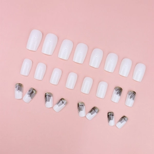 Set di unghie finte bianche eleganti con motivi floreali a inchiostro nero e glitter