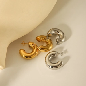 Detailed view of polished chunky C-hoop earrings in gold and silver stainless steel