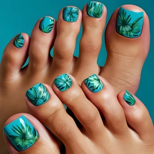 Detail of green press-on toenails featuring realistic botanical leaf patterns and glossy finish