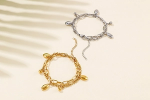 Details des doppellagigen Titanstahl-Kettenarmbands mit gold- und silbernen Oval-Anhängern