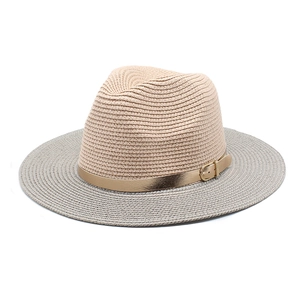 Detail of two-tone woven panama straw hat with a decorative gold mirror buckle accent
