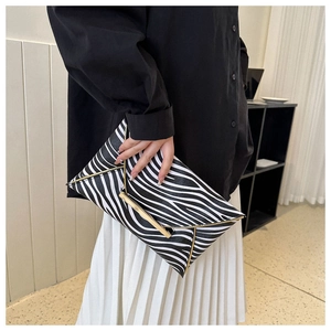 Close-up of zebra pattern envelope clutch bag with elegant gold metal frame and trim