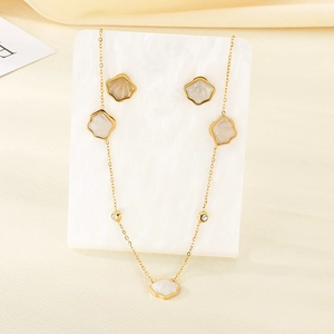 Detail of shell flower pendant and earrings set with tiny crystals on gold finish