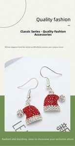 Close-up of Christmas hat earrings with red and white rhinestones on a festive background
