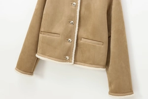 Detail der hellbeige Wildlederjacke mit silbernen Metallknöpfen und weißem Lammfellbesatz
