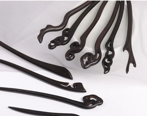 Close-up of hand-carved black ebony wood hairpins with traditional Chinese patterns