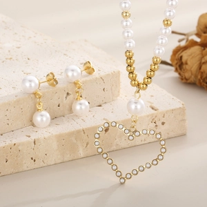 Détail du collier coeur doré avec perles et boucles d'oreilles perles assorties