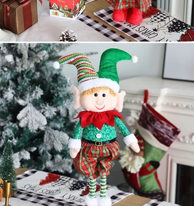 Close-up of a festive Christmas elf doll in green and red outfit on a decorated dinner table