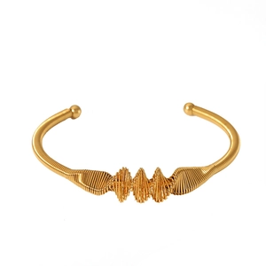 Close-up of gold knotted cable bracelet with twisted metallic texture and ball ends